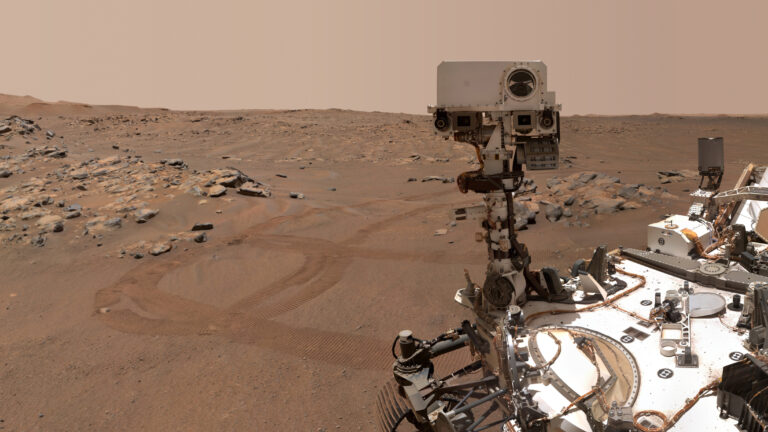 NASA’s Perseverance rover on the surface of Mars, with its instrument mast visible against the rocky landscape of Jezero Crater.