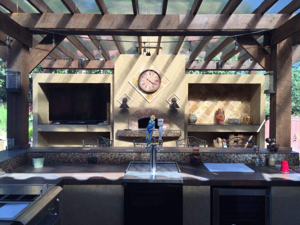 Covered outdoor kitchen and patio bar with counter space, lighting and built-in features.